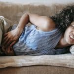 Woman Suffering from a Stomach Pain Lying Down on Couch